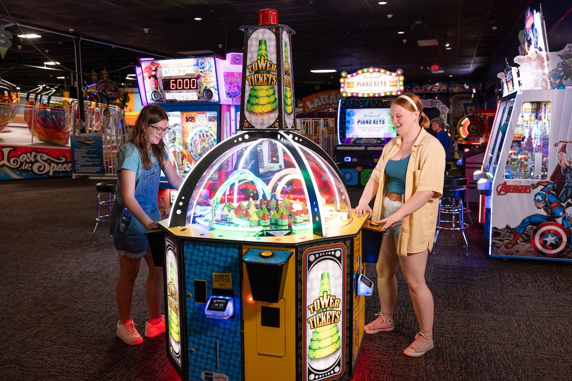 This video shows two teenage girls playing a colorful redemption game at an Incredible Pizza location.