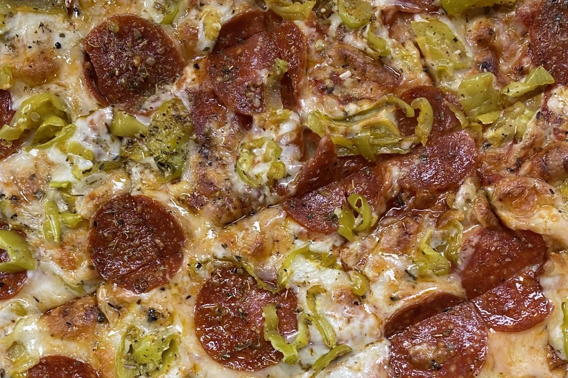 This photo shows a close-up view of a pizza topped with pepperoni and mushrooms for Stefanina's.