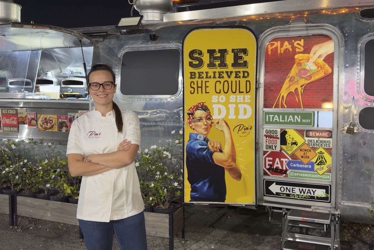 This photo shows Francis Di Mattia standing with her arms crossed in front of her food trailer.