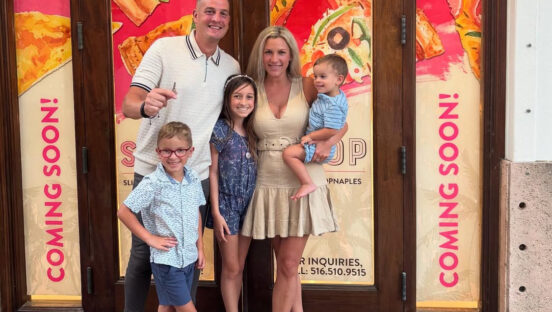 This photo shows Rob Guercio, his wife Nicole, and their three children standing in front of their store before it opened. Behind them signs read "Coming Soon."