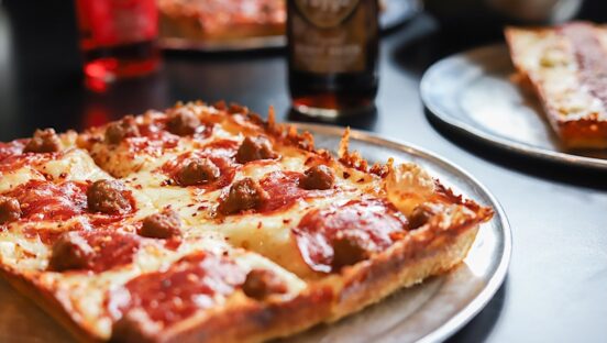This photo shows a whole Detroit-style pizza on a tray.