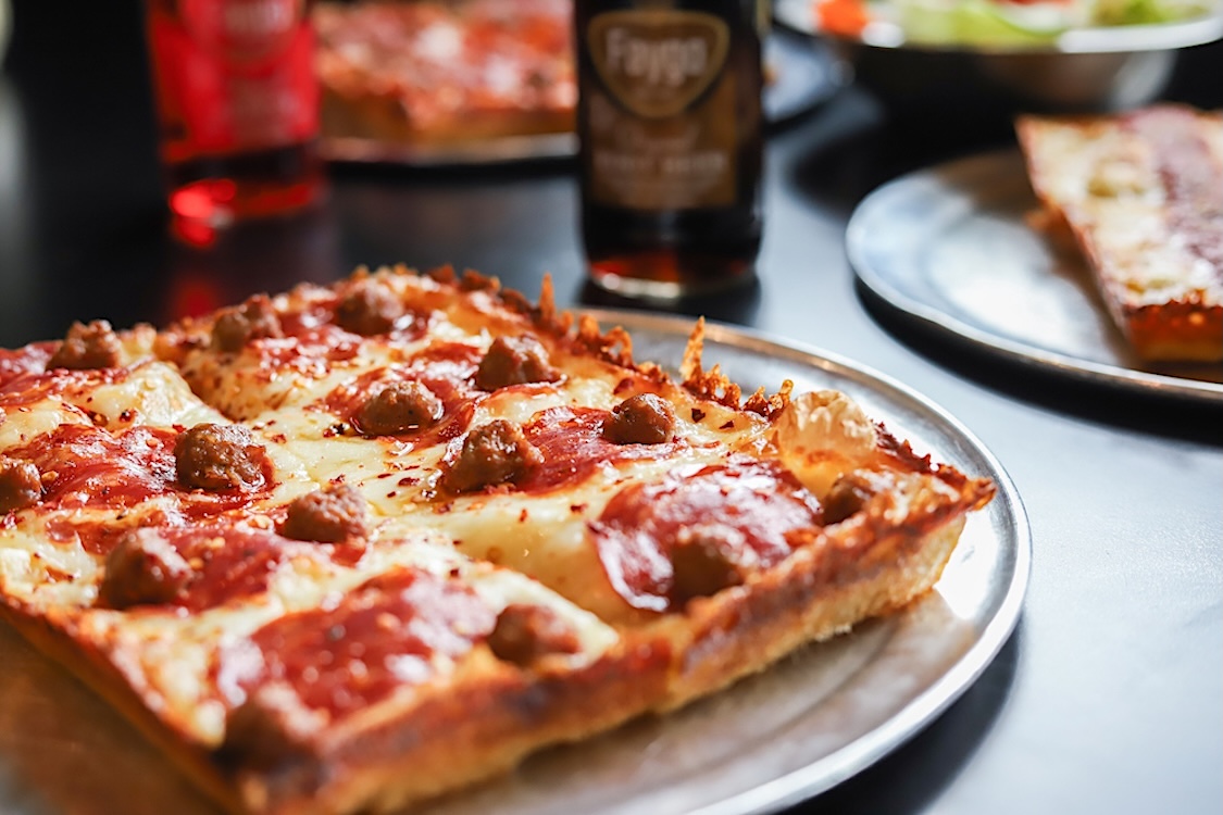 This photo shows a whole Detroit-style pizza on a tray.