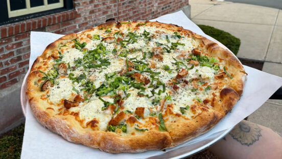 This photo shows a white pie from Joey Garlic's with chicken and broccoli