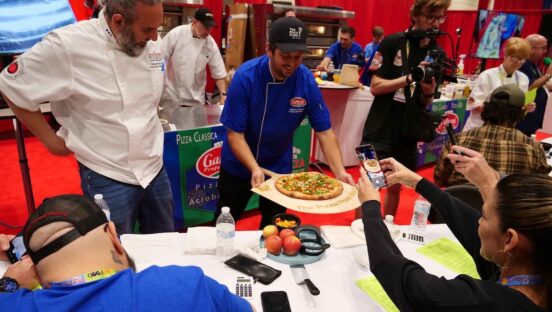 This photo shows Alejandro Burgaleta presenting his winning pie to the judges at the event.