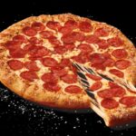This photo shows Little Caesars' stuffed-crust pizza, with a little cheese oozing out from an extracted slice.