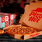 This photo shows a pepperoni pizza in a Pizza Hut box next to the newly repackaged Triple Treat Box.