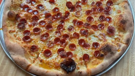 This photo shows a close-up of a whole pepperoni pizza from Paulie Gee's.