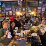 This photo shows a large group of customers smiling for the camera in a busy night at The Original Roma Pizza restaurant.