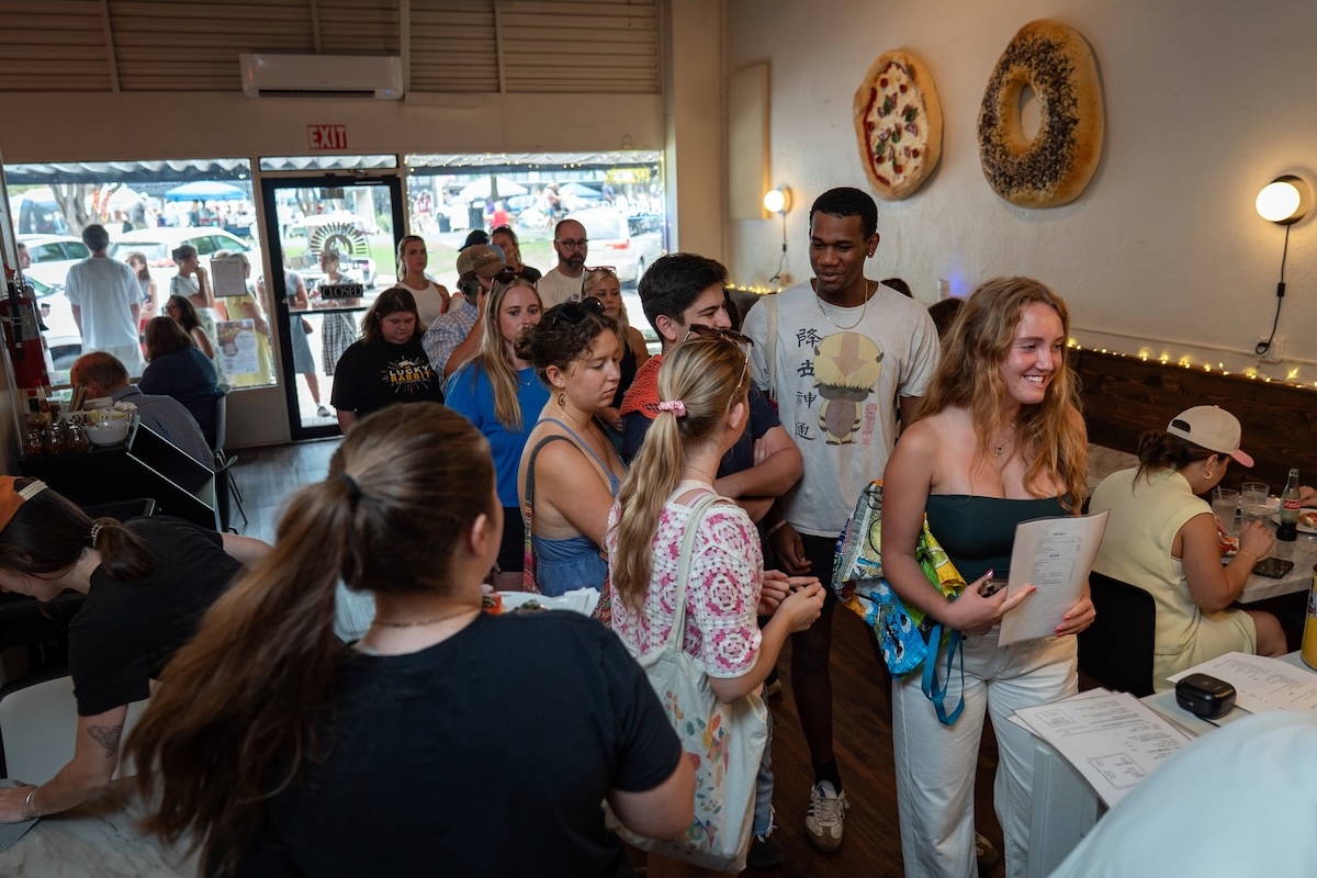 This photo shows a long line of customers waiting to place an order at Lena Pizza & Bagels.