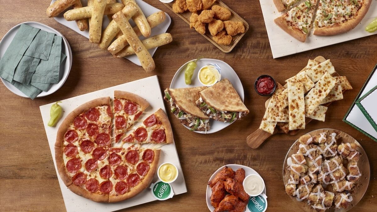This photo shows a variety of Papa Johns' menu items, including a pepperoni pizza, breadsticks, Papadillas, chicken wings and more.