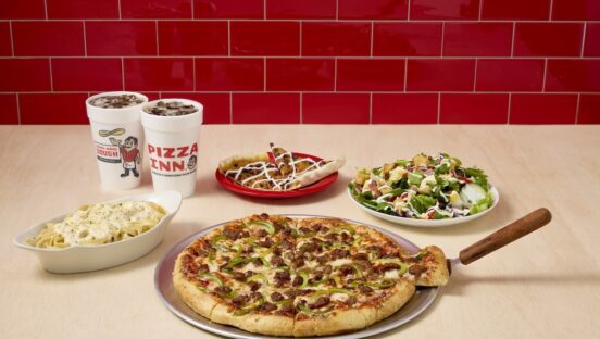 This photo shows items from the Pizza Inn buffet, including a pizza, salad, Pizzert, a dish of pasta and drinks.