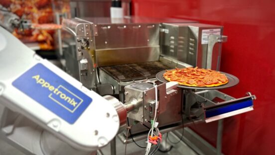 This photo shows Pepptron's robotic arm removing a baked pepperoni pizza from the conveyor oven.