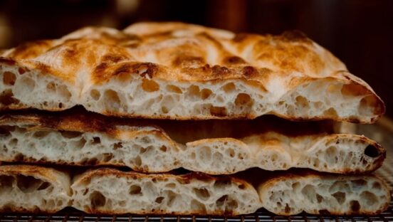 This photo shows a side view of the crust of three Roman-style pizzas stacked on top of each other.