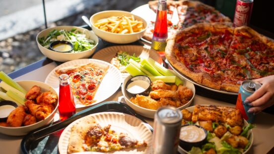 This photo shows a wide array of menu items at Barclay Pies, including pizzas, wings, salads and fries, plus various beverages.