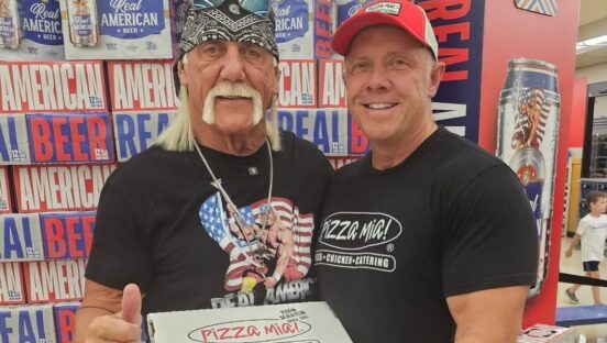 This photo shows Dave Dombrowski standing next to Hulk Hogan, who is holding a pizza box and giving the thumbs-up sign.
