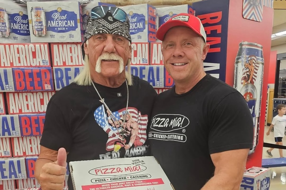 This photo shows Dave Dombrowski standing next to Hulk Hogan, who is holding a pizza box and giving the thumbs-up sign.