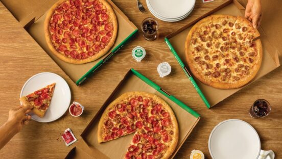 This photo shows a variety of pizzas in delivery boxes.