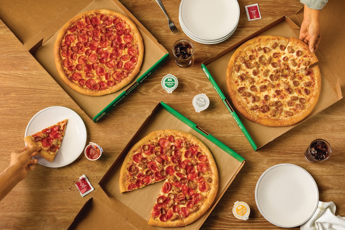 This photo shows a variety of pizzas in delivery boxes.