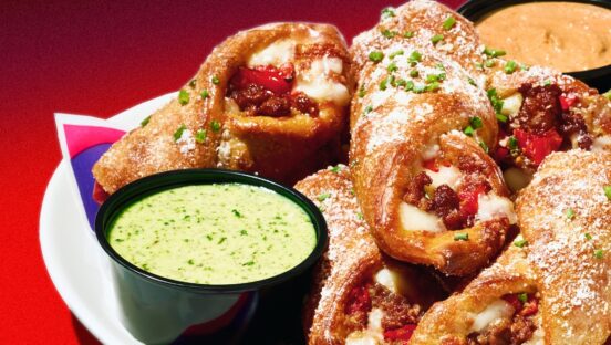 This photo shows a sausage roll from Mellow Mushroom served in a plate with a side of dipping sauce.