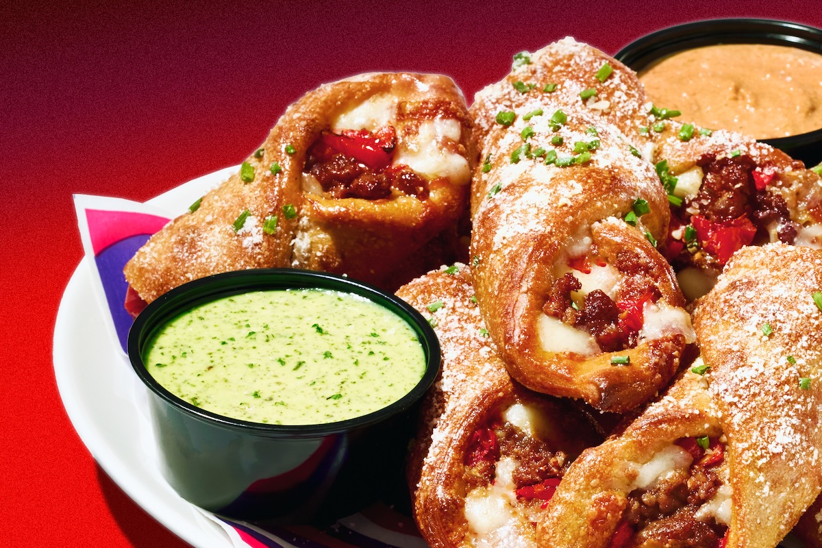 This photo shows a sausage roll from Mellow Mushroom served in a plate with a side of dipping sauce.