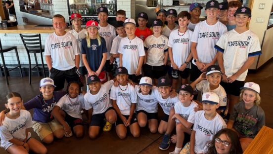 This photo shows a large group of Little League players in the dining room at Nello's Pizzeria.
