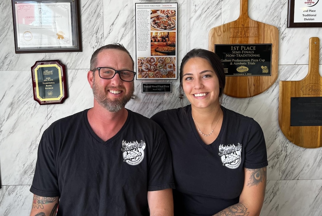 This photo shows Craig and Desirae sitting together in an area of their restaurant.