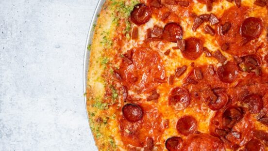 This photo shows a pizza topped with three different types of pepperoni.