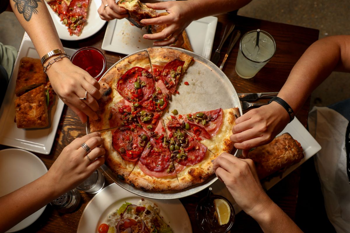This photo shows customers sharing a pizza from Pizza Domenica in New Orleans.