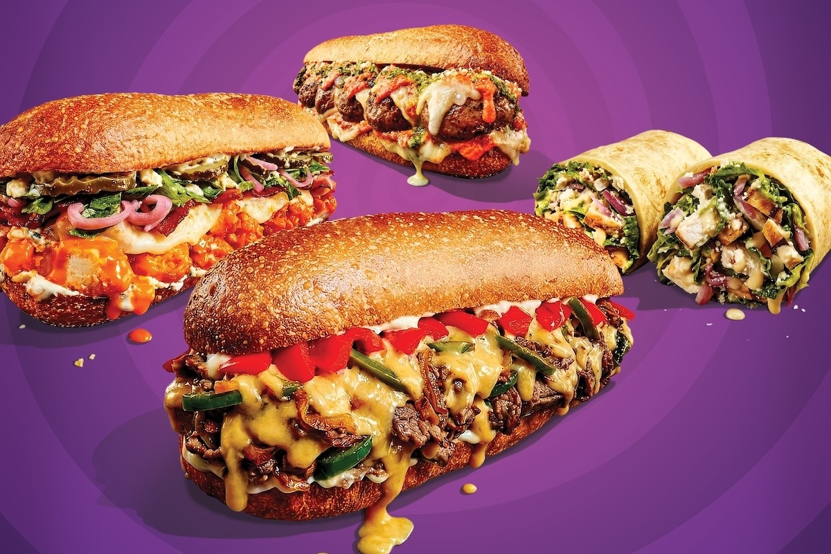 This photo shows various menu items that are described in the article itself, including the Beer Cheese Philly, the Meatball Parmesan and the Pesto Chicken sandwiches in the foreground, and two wraps in the background.