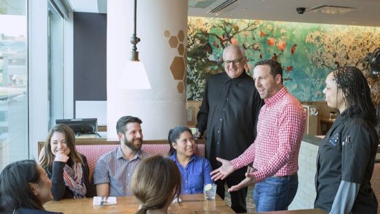 Dan Simons of Founding Farmers meets with employees.