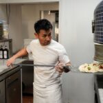 Tsubasa Tamaki, pizzaiolo at Pizza Studio Tamaki, tends the oven at his New York City pizzeria.