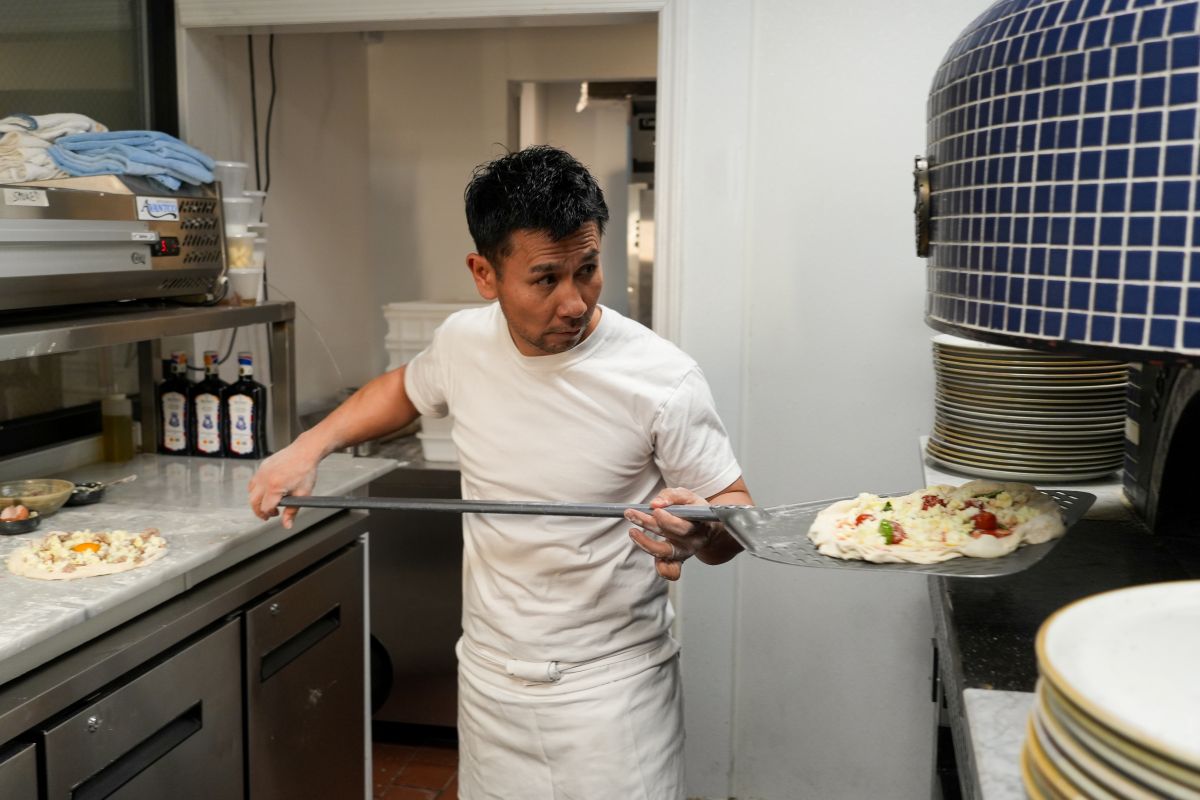 Tsubasa Tamaki, pizzaiolo at Pizza Studio Tamaki, tends the oven at his New York City pizzeria.