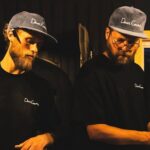 This photo, shot with dark moody lighting, shows Silvio and Paul working side by side making pizza in the kitchen at Dear Emma.