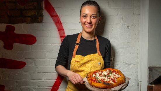 Pizzaiola Giorgia Caporuscio holds a pizza