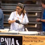 This photo shows Kira Zabrowski in a white U.S. Pizza Team chef coat working on a recipe at the California Pizza Challenge.