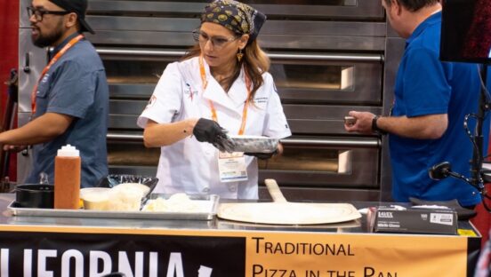 This photo shows Kira Zabrowski in a white U.S. Pizza Team chef coat working on a recipe at the California Pizza Challenge.