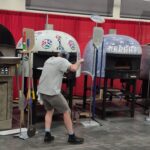 This photo shows Silvio peeling his pizza into a dome-shaped oven at Pizza Expo.