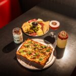 this photo shows an Elote street corn pizza alongside a meat and cheese board from Via 313.