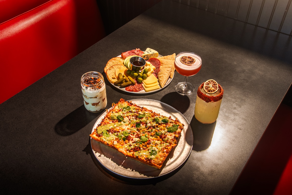 this photo shows an Elote street corn pizza alongside a meat and cheese board from Via 313.
