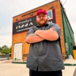 Benjamin Hoover, executive chef and co-owner, stands in front of Franky’s Pizza & Delicatessen in Warren, Ohio