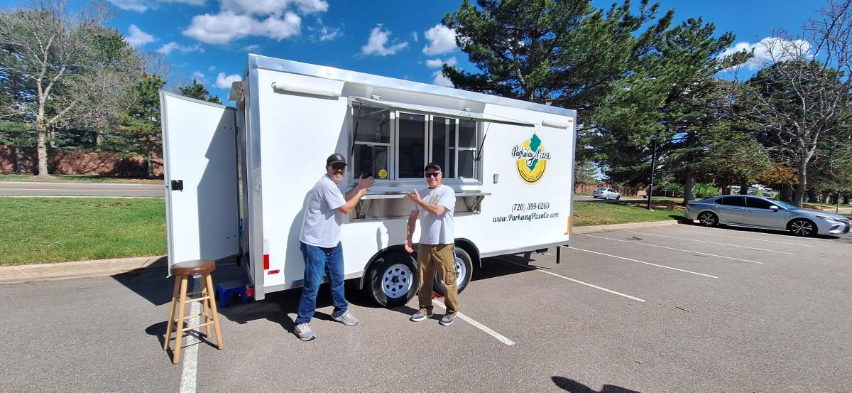 Ron Hurley and John Schultz pose in front of their mobile business, Parkway Pizza in Littleton, Colorado