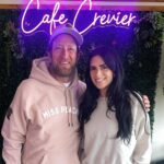 This photo shows a smiling Dave Portnoy with his arm around a smiling Brittany Crevier in front of the Café Crevier sign.