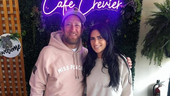 This photo shows a smiling Dave Portnoy with his arm around a smiling Brittany Crevier in front of the Café Crevier sign.