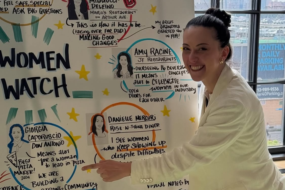 This photo shows Giorgia Caporuscio in front of a sign touting 10 Women to Watch in the hospitality industry at the NYSRA Women in Hospitality conference.