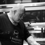 This black-and-white photo shows Martucci working at his oven in his restaurant.