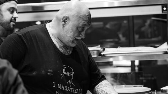 This black-and-white photo shows Martucci working at his oven in his restaurant.