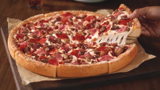 This photo shows a meat lovers pizza with a thick crust.