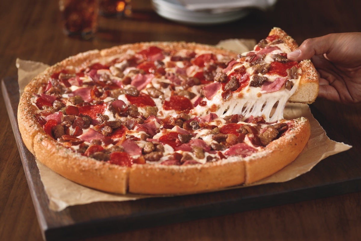This photo shows a meat lovers pizza with a thick crust.