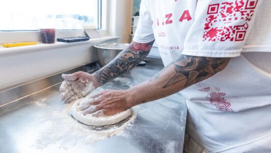 A pizza maker presses dough at Piazza Pizza & Beach Bodega in Pensacola, Florida