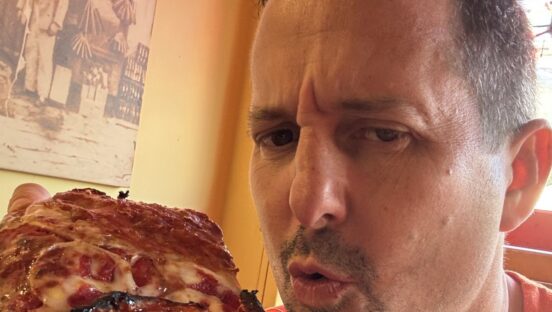 Matt Plapp of America's Best Restaurants eats a slice of pizza